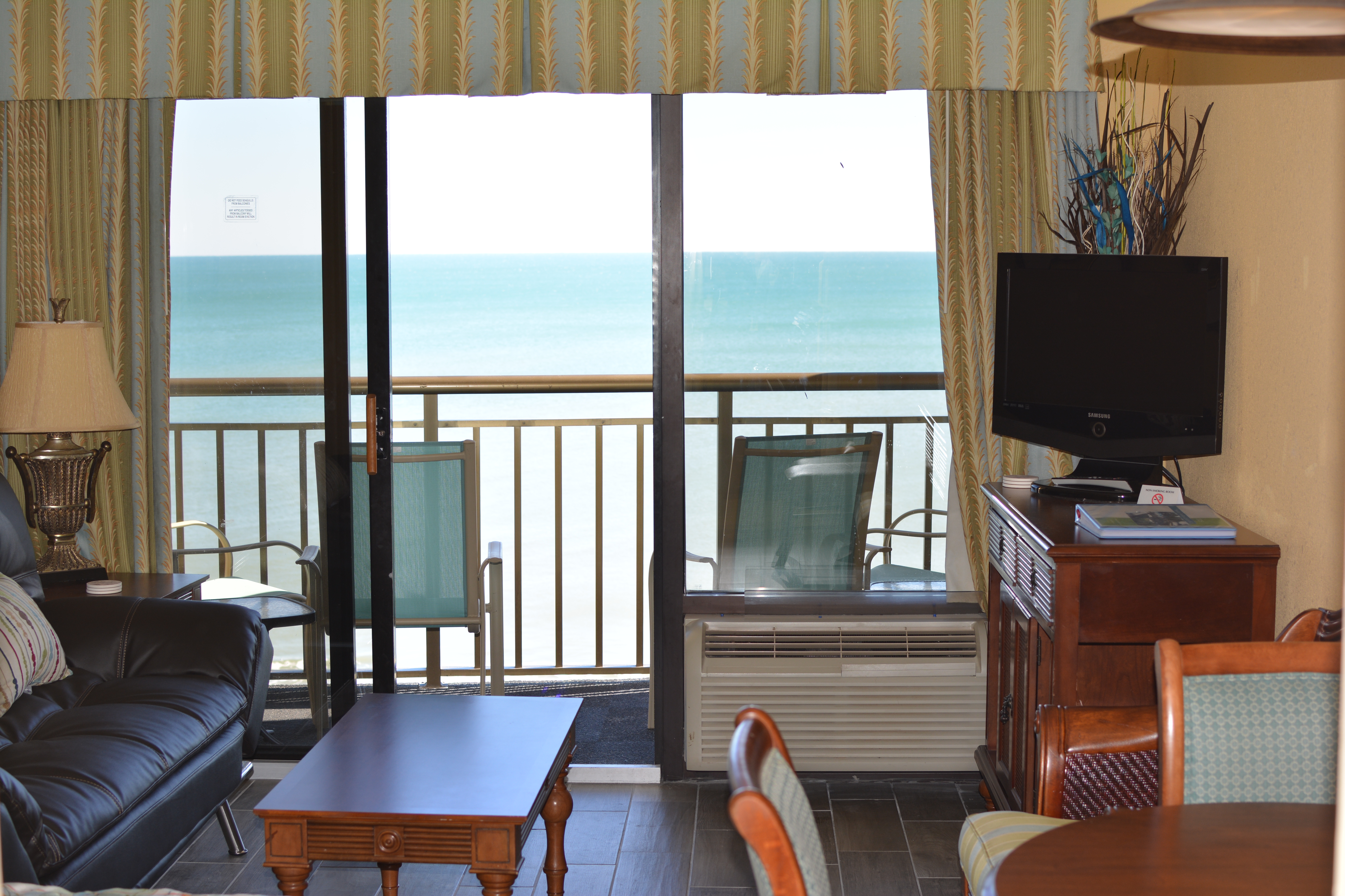 Holiday Pavilion Oceanfront Resort Family Vacation Rental Condo - Leather double reclining couch in living area overlooking the beach