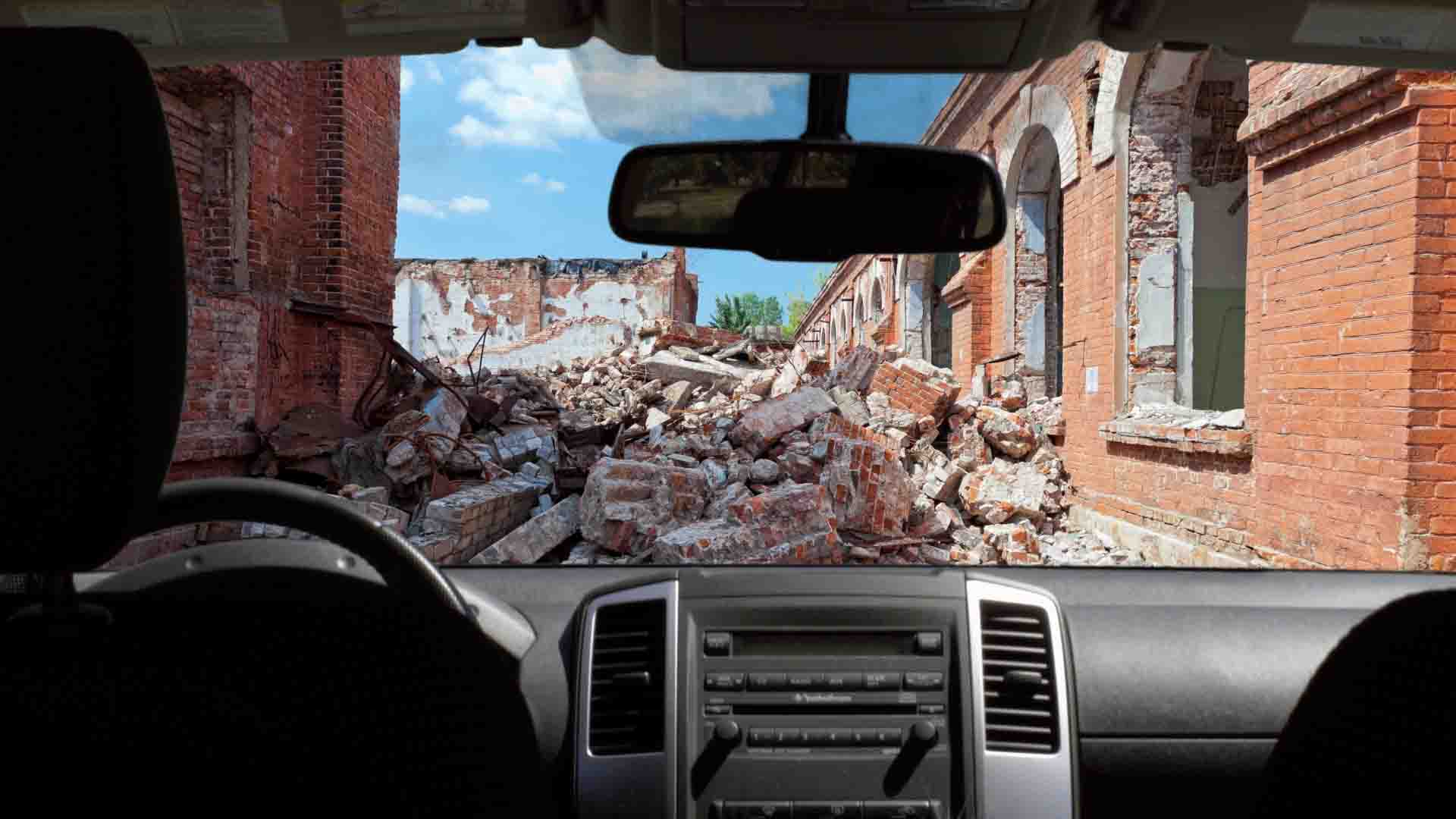 Seeing composite image outside of vehicle, destroyed road and town.