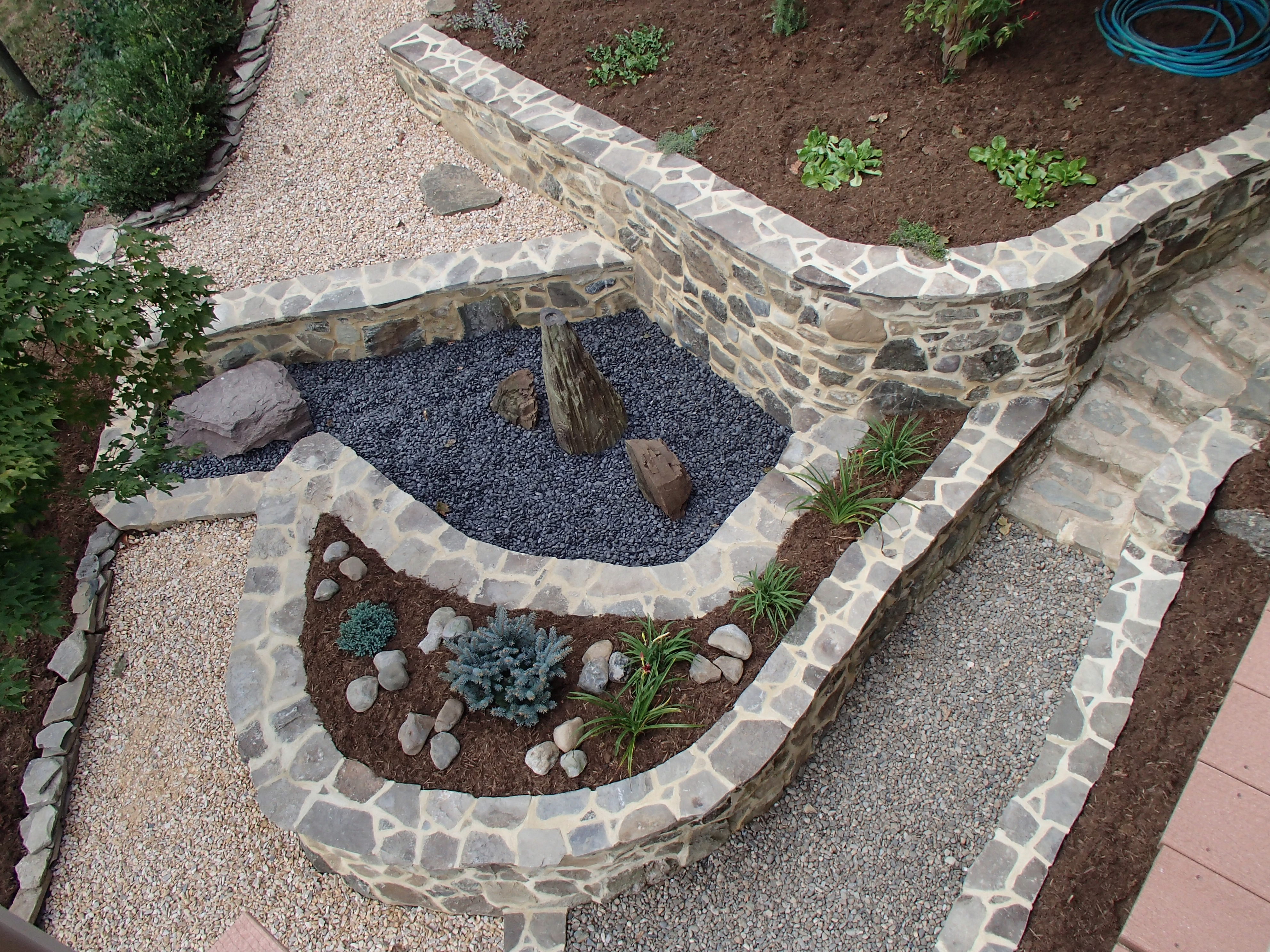 Hardscape project with natural stone retaining walls, landscape and pondless fountain